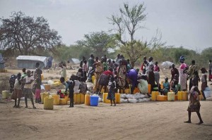 Children and women displaced by recent fighting in South Sudan gather near jerry cans and other water supplies in the town of Mingkaman, where humanitarian assistance is being provided.  Photo © UNICEF/NYHQ2014-0359/Holt.