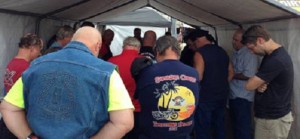 At the Sturgis Motorcycle Rally, evangelism volunteers join in prayer at the start of a three-hour shift before venturing into their outreach of three-minute testimonies among nearly a half-million bikers, wannabes and gawkers.