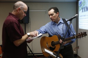 Jeff Guillard, left, and Michael Johnson go over the schedule for Sunday worship before the River Church meeting in the Community Room in Moxee City Hall in Moxee, Wash. on Oct. 19, 2014. (KAITLYN BERNAUER)