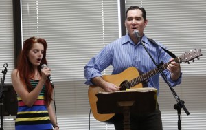 Michael Johnson and his oldest daughter, Olivia, 15, lead the group in singing, "Burning in my Soul" at the beginning of the River Church meeting in the Community Room in Moxee City Hall in Moxee, Wash. on Oct. 19, 2014. (KAITLYN BERNAUER)