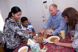 Following their immigration to the United States, a couple shares a meal with a host family in Mobile, Alabama. Photo by Lyle Ratliff